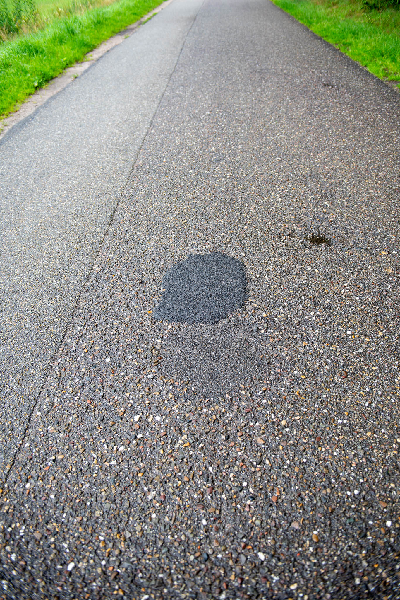 Kuil in wegdek hersteld met reparatieasfalt